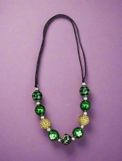 Adjustable wax-coated rope chunky bead necklace with green plaid, gold rhinestone, solid green, and white four-leaf clover beads.