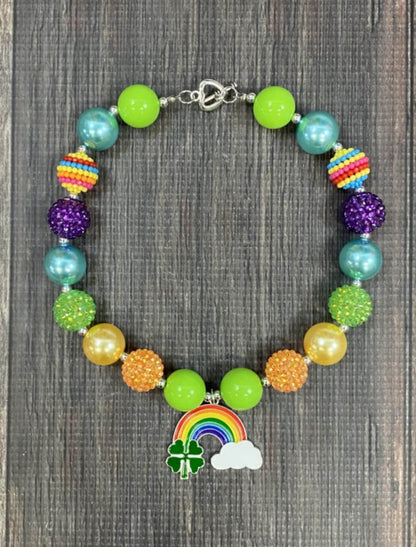 Four-leaf clover, rainbow with cloud pendant chunky bead necklace with sparkly lime green, purple, orange, and solid blue, lime green beads, and a heart toggle closure.