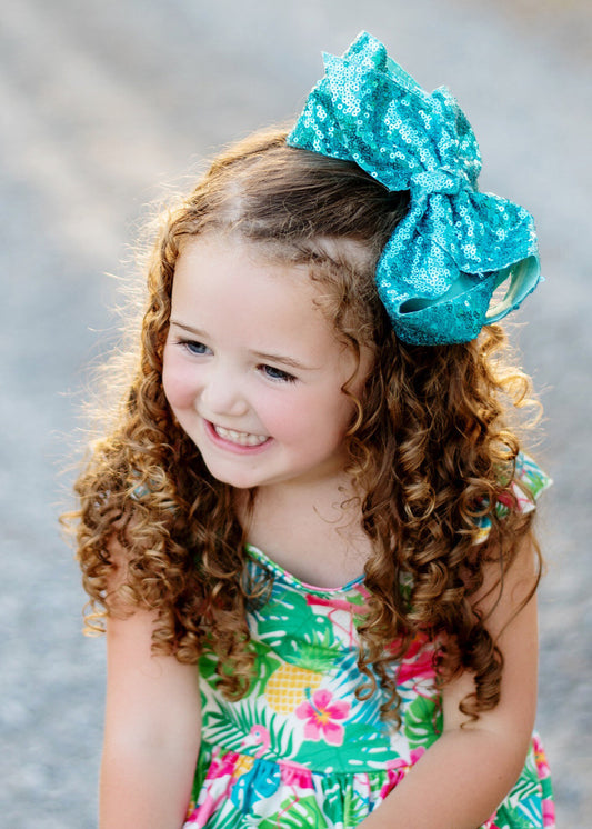 Texas size sequin bow in turquoise on model