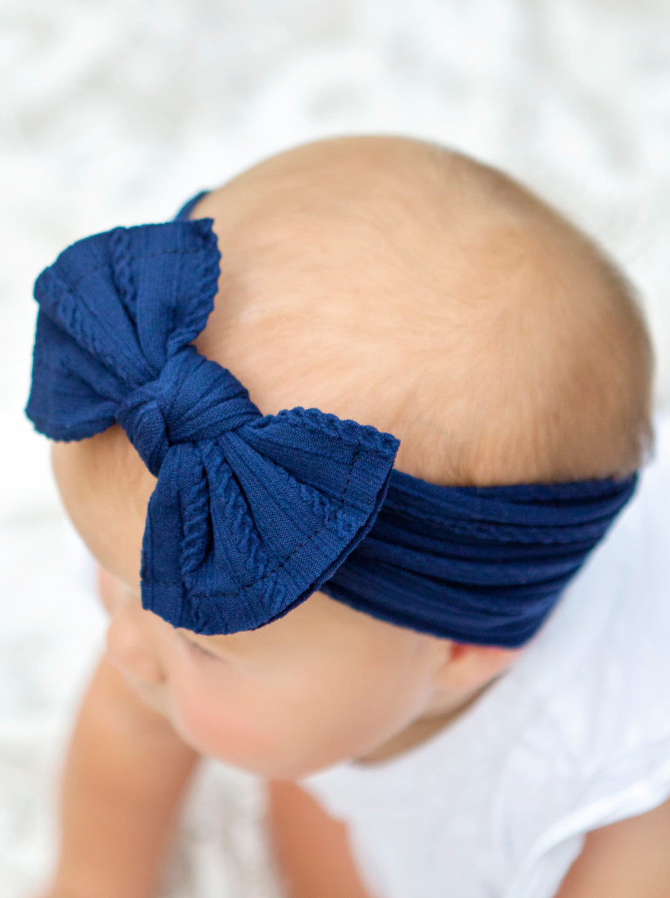 Cable knit bow headbands in navy on model