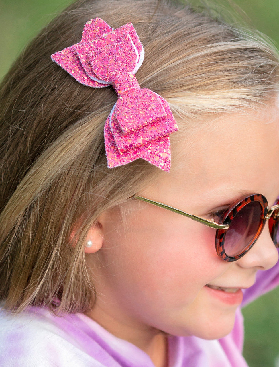 Glitter bow clippie in pink on model