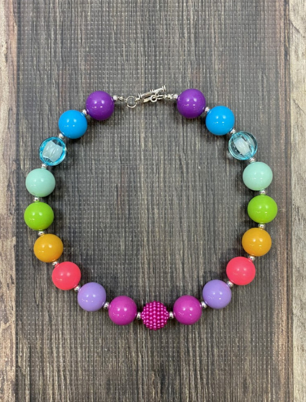 Chunky bead necklace in bright rainbow colors with heart clasp. Approximately 17".