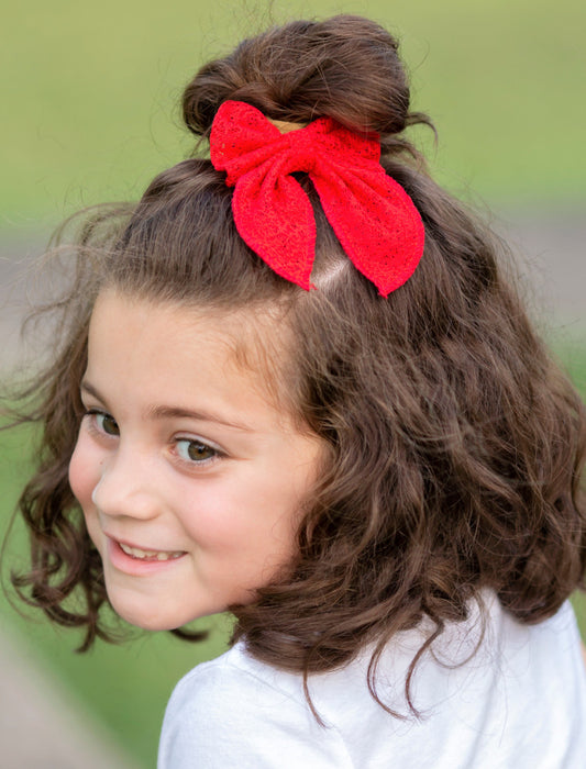 Eyelet lace hair bow on model in red