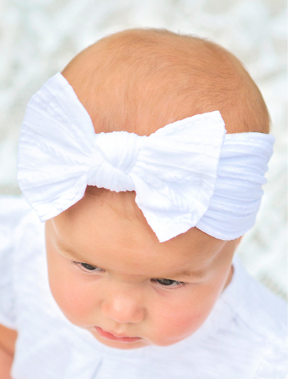 Cable knit bow headbands in white on model